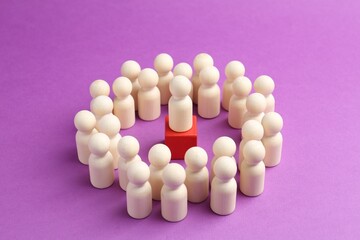 Human figures around red cube with white figure on violet background, closeup. Competition concept