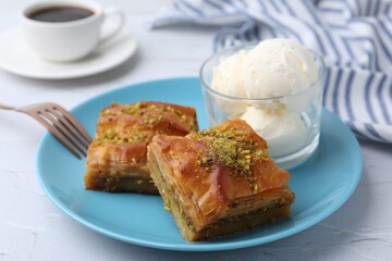 Tasty baklava with chopped nuts and scoops of ice cream on white table, closeup