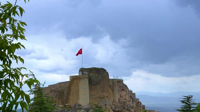 Harput fortress with the Turkish flag, in the spring in Eastern Anatolia, Elazig, Turkey. Harput Castle or Harberd, also known as Sut Kalesi. Ancient city. 4К