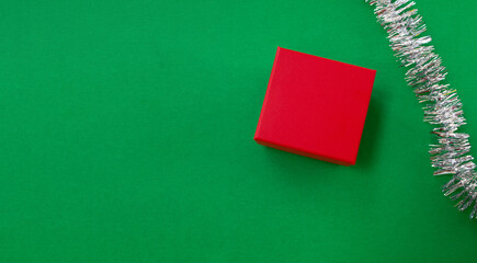 New Year holiday background. Gift and tinsel on a green background.