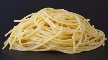 Cooked spaghetti pile on dark background.