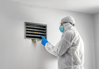 Mold inspection specialist pointing at moldy air vent, highlighting the need for remediation