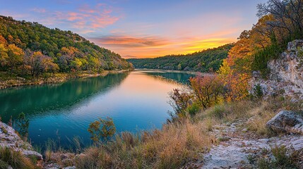 Naklejka premium Serene autumn sunset over a calm river valley.
