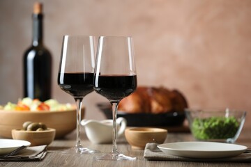 Red wine and delicious dinner served on wooden table, space for text