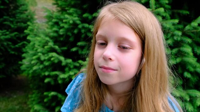 A nine-year-old girl calmly looks at the camera.