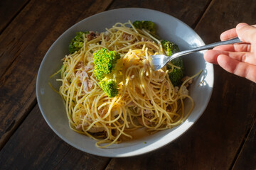 手作りのツナとブロッコリーのスパゲッティ_フォークを持つ手