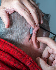 Grandfather putting on hearing aids to listen to his grandfather's music