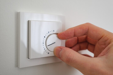 Hand adjusting the indoor heater setting, close up shot