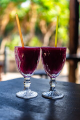 Delicious Prickly Pear Juice in a Clear Glass on Rustic Wooden Table for Healthy Refreshing Drink and Natural Wellness. Bananas in the Background