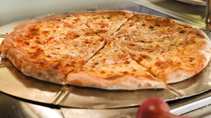 Foto de uma deliciosa pizza de mussarela recém-assada, servida em uma bandeja de metal, destacando a crocância da massa e o queijo derretido sobre a pizza
