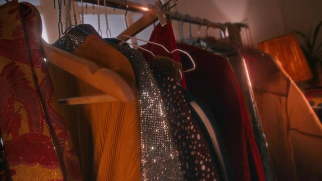 No people low key shot of rack with glittery and fashionable clothes for 70s disco stars performance in dressing room