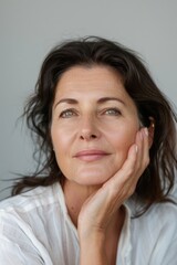Portrait of a woman with analytical expression, possibly middle age, professional and confident.