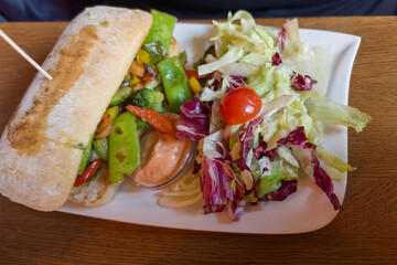 Ciabatta with baked vegetables and salad of fresh vegetables