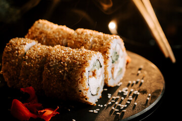 Fresh sushi with sesame and ginger on a black background. Sushi concept