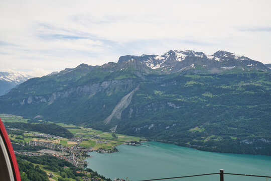 Stunning view of Brienz, Switzerland, showcasing majestic mountains, lush greenery, and serene turquoise waters reflecting the sky.