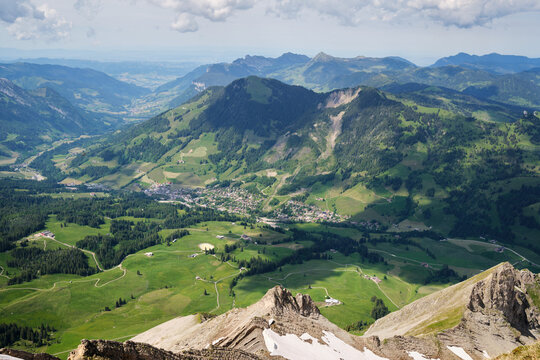 Breathtaking view of lush green valleys and rugged mountains in Switzerland, showcasing the town of Brienz nestled among the picturesque landscape.