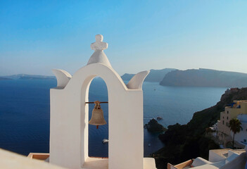Old bell on a Christian church dome against the background of the blue Caldera of Santorini island in Oia.