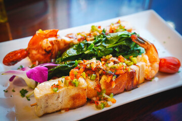 Tapas of Seafood Skewer served on the white plate