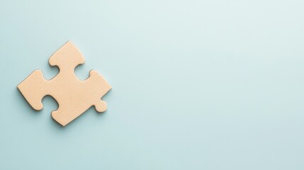 Fototapeta premium Single wooden puzzle piece on a soft blue background representing unity, problem-solving, and creativity in image composition, suitable for various design projects and themes