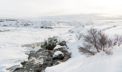 urriðafoss urridafoss waterfall in Iceland during winter. Frozen riverbanks with ice and volcanic rock. Cliffs on Þjórsár river. South coast of iceland. Tourist must-see destination.