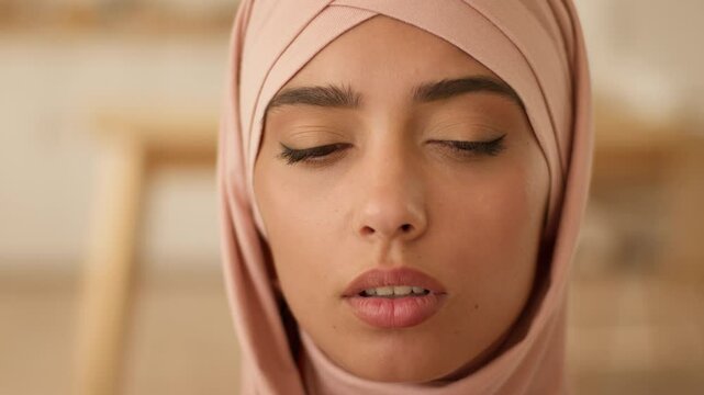 Close up face portrait sad stressed upset serious shy Arabian woman Islam girl Muslim female in hijab talking online video call conference virtual communicate indoors businesswoman business interview