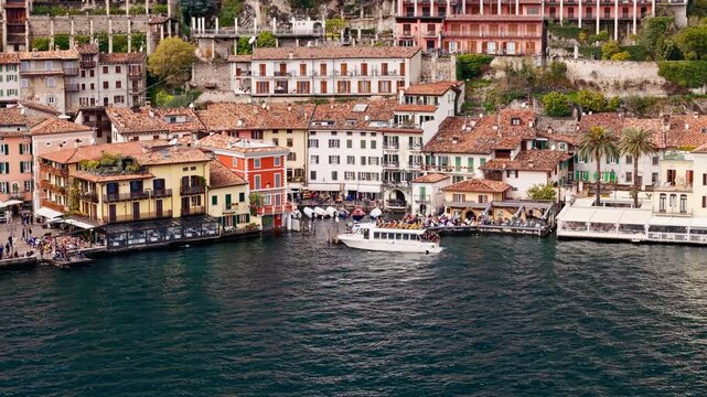 Passengers sailing boat arrive to Limone sul Garda on Lake Garda. Tourist and leisure transport on the Italian lake