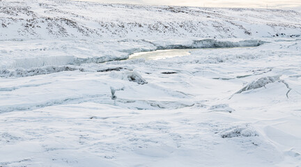 Obraz premium urriðafoss urridafoss waterfall in Iceland during winter. Frozen riverbanks with ice and volcanic rock. Cliffs on Þjórsár river. South coast of iceland. Tourist must-see destination.