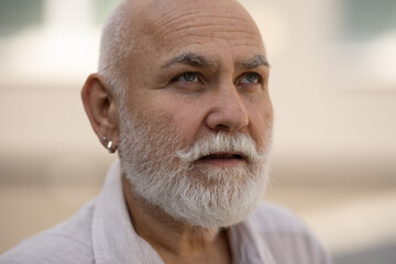 Middle-aged senior grandfather close up portrait. Grey hair white beard old man. Senior serious. Face of bearded senior age man. Closeup emotional portrait of an old mature senior man with grey beard.