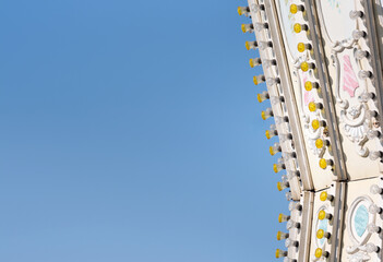 fragment of a children's carousel in an amusement park against the sky