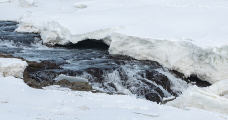 urriðafoss urridafoss waterfall in Iceland during winter. Detailed view of thick layer of ice and snow on Frozen riverbanks with ice and volcanic rock. Ice Cliffs on Þjórsár river. South coast of icel
