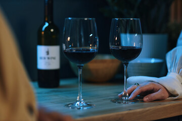 Close-up of wineglasses with red wine standing on table in the kitchen