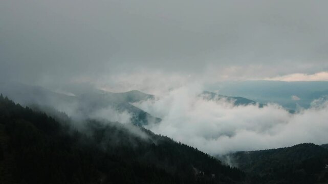 Aerial mystical view of clouds descending on a village between the mountains in Sakarya, Turkey