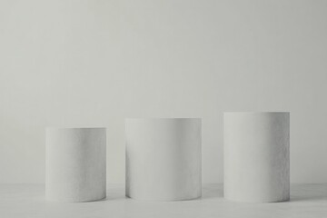 Simple cylindrical forms arranged in minimalistic setting evoke