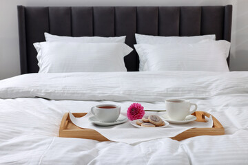 Breakfast tray on bed with beautiful linens indoors