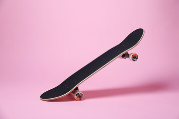 One skateboard on pink background. Sports equipment