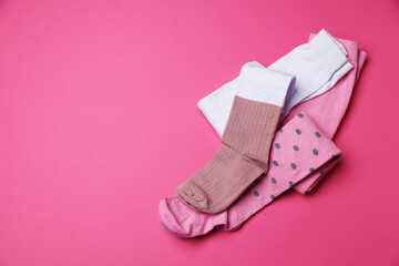 Different child's tights on pink background, above view. Space for text