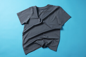 One grey t-shirt on light blue background, top view