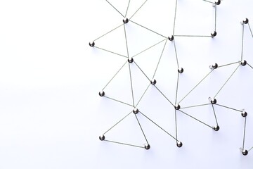 Network connection. Nails linked together by threads on white background, flat lay. Space for text