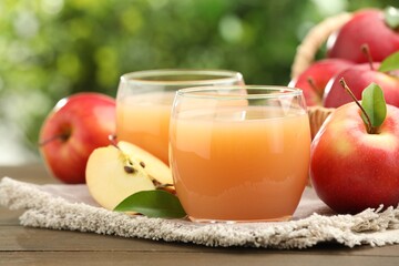Tasty apple juice and fresh fruits on wooden table against blurred background, closeup