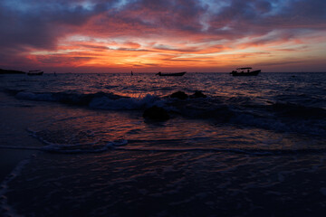 Landscape in sunset beach of caribean beach, colorful sky with boats