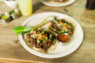 Delicious tacos with a side of spicy salsa, perfect for enjoying at a traditional mexican taqueria