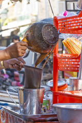 Man pours boiling water over a cloth filter containing ground coffee at a cafe in Phnom Penh