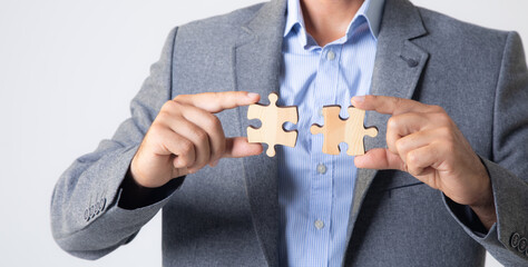 businessmen holding puzzle pieces