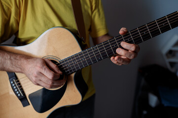 Guitarist on acoustic guitar playing melody in studio. Close up musician instrument