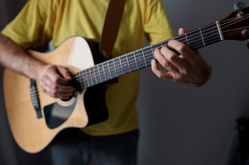 Obraz premium Guitarist on acoustic guitar playing melody. Close up musician instrument with pick in hand