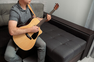 Obraz premium Guitarist on acoustic guitar playing melody in studio. Close up musician instrument