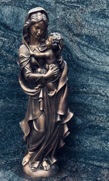Muttergottes-Statue mit Kind auf einem Grabstein