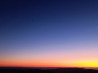 a blue sky with a star and a moon in the background