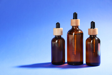 Bottles of skin care products on blue background, space for text