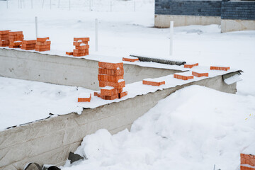 Bricks are meticulously stacked and carefully arranged atop one another in the soft, fluffy white...